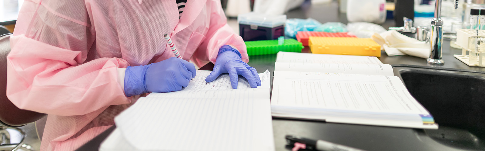 student taking notes in a lab