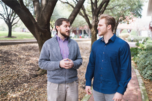 professor walking with student while talking to each other outside 