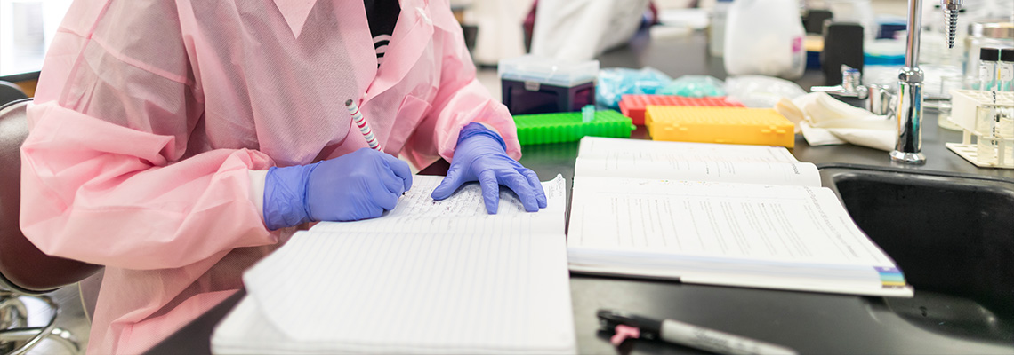 student taking notes in a lab