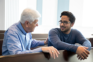 male professor talking with student in the chapel