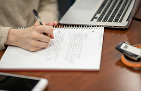 student writing on paper