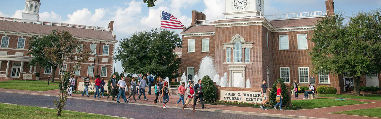 DBU students standing in front of Pilgrim Chapel with Patriot Man